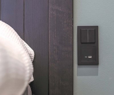 svart usb laddare monterad vid säng